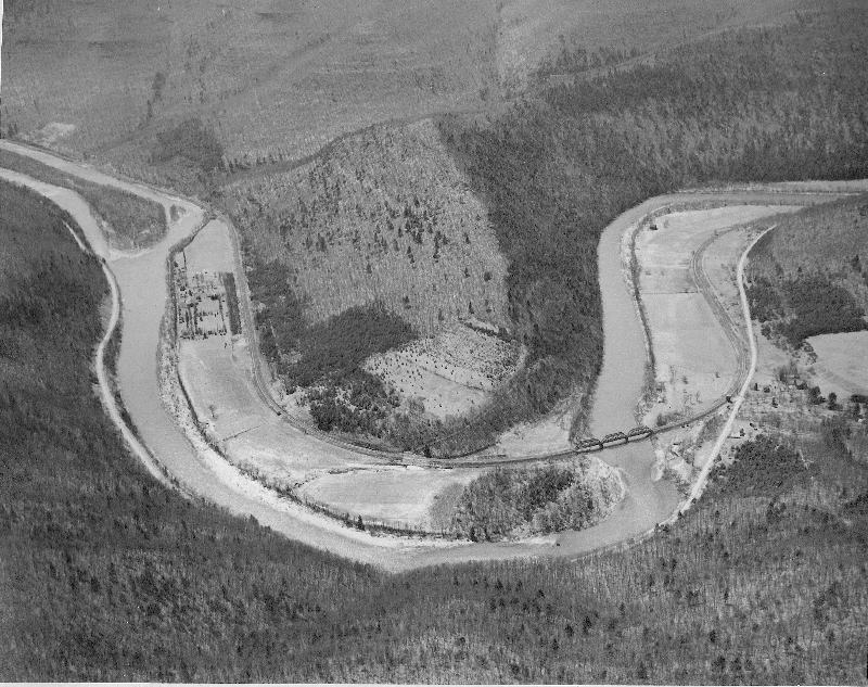 The horseshoe–shaped curve of Pine Creek at Ramsey is vividly evident from this panoramic view taken from the mountaintop southeast.  Just to the right of the railroad bridge over Pine Creek is the New York Central Railroad’s water tower, razed in the 1950s.  On the left side of the horseshoe curve is the Boy Scout Camp Kline, with its "circular" Vallamont Theater dining hall, brought on the railroad in pieces from Williamsport in 1921.